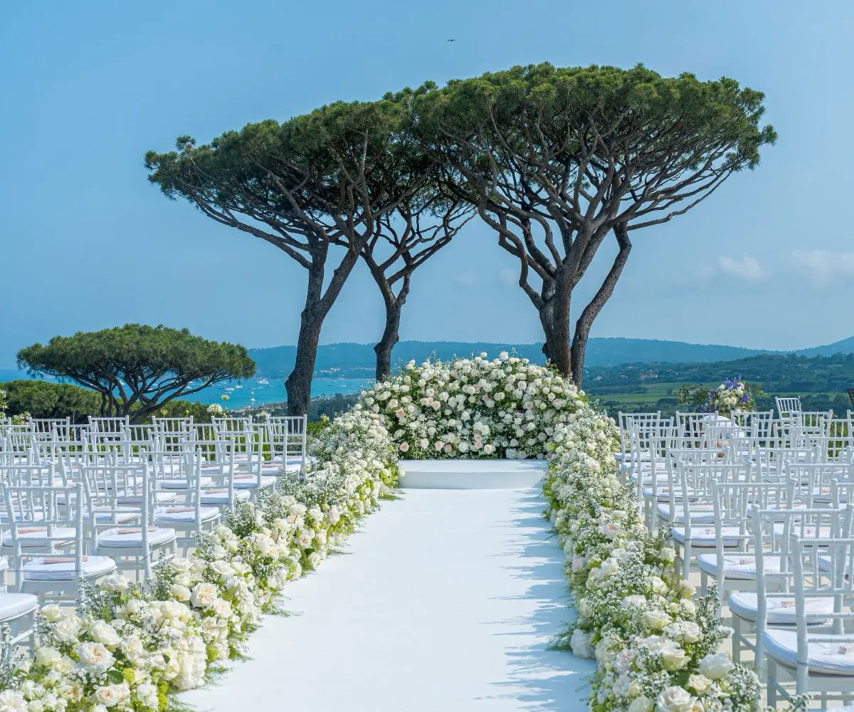 Décor de cérémonie de mariage à Saint-Tropez, avec une scénographie florale riche et élégante réalisée en bord de mer.