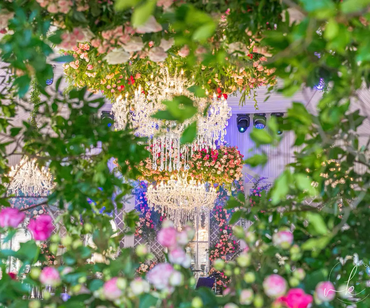 Décoration florale spectaculaire entourant des lustres élégants lors d’un mariage de luxe à Saint-Tropez, avec des compositions abondantes et raffinées.