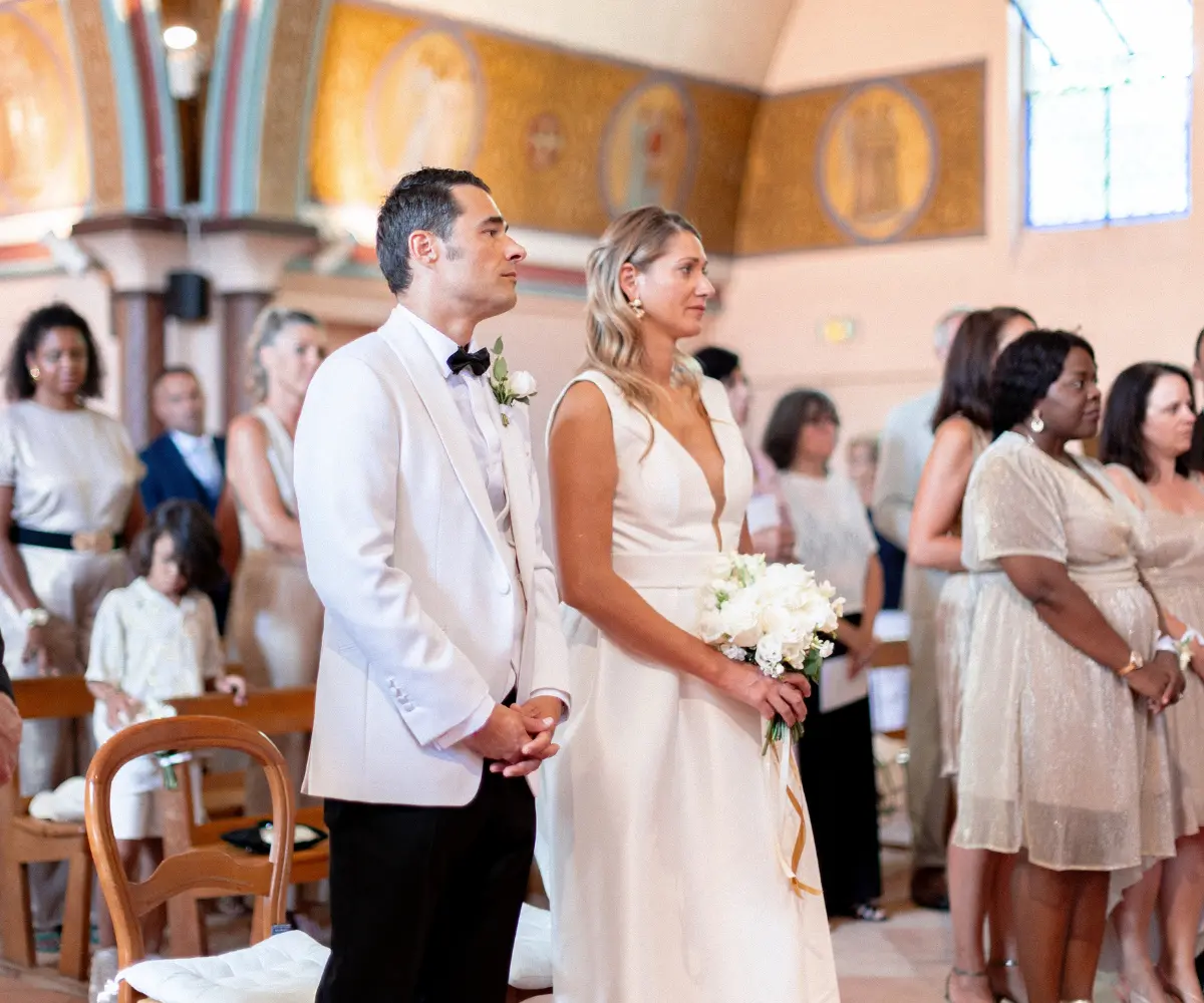 Couple de mariés s’unissant lors d’une cérémonie religieuse dans une église à Arcachon, dans une atmosphère solennelle et lumineuse.