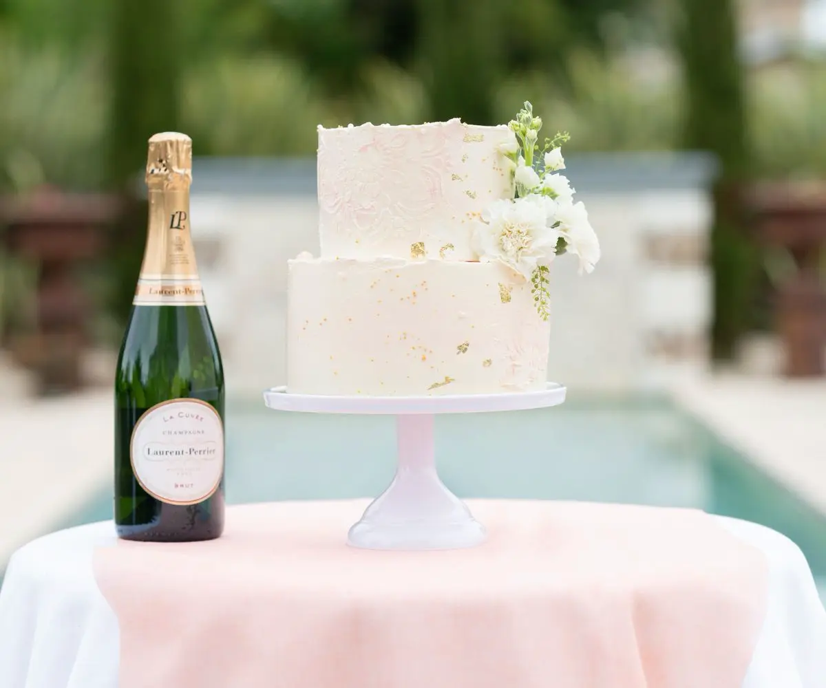 Gâteau de mariage à étages, décoré avec finesse en rose, blanc et touches dorées, reflétant un style élégant et raffiné.