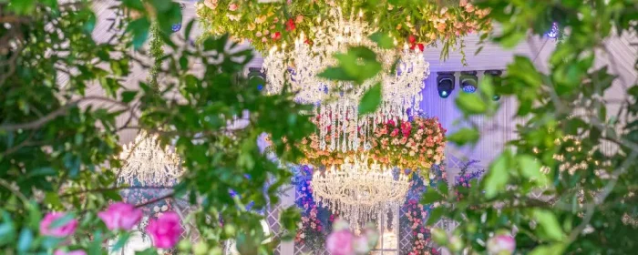 Décoration florale spectaculaire entourant des lustres élégants lors d’un mariage de luxe à Saint-Tropez, avec des compositions abondantes et raffinées.